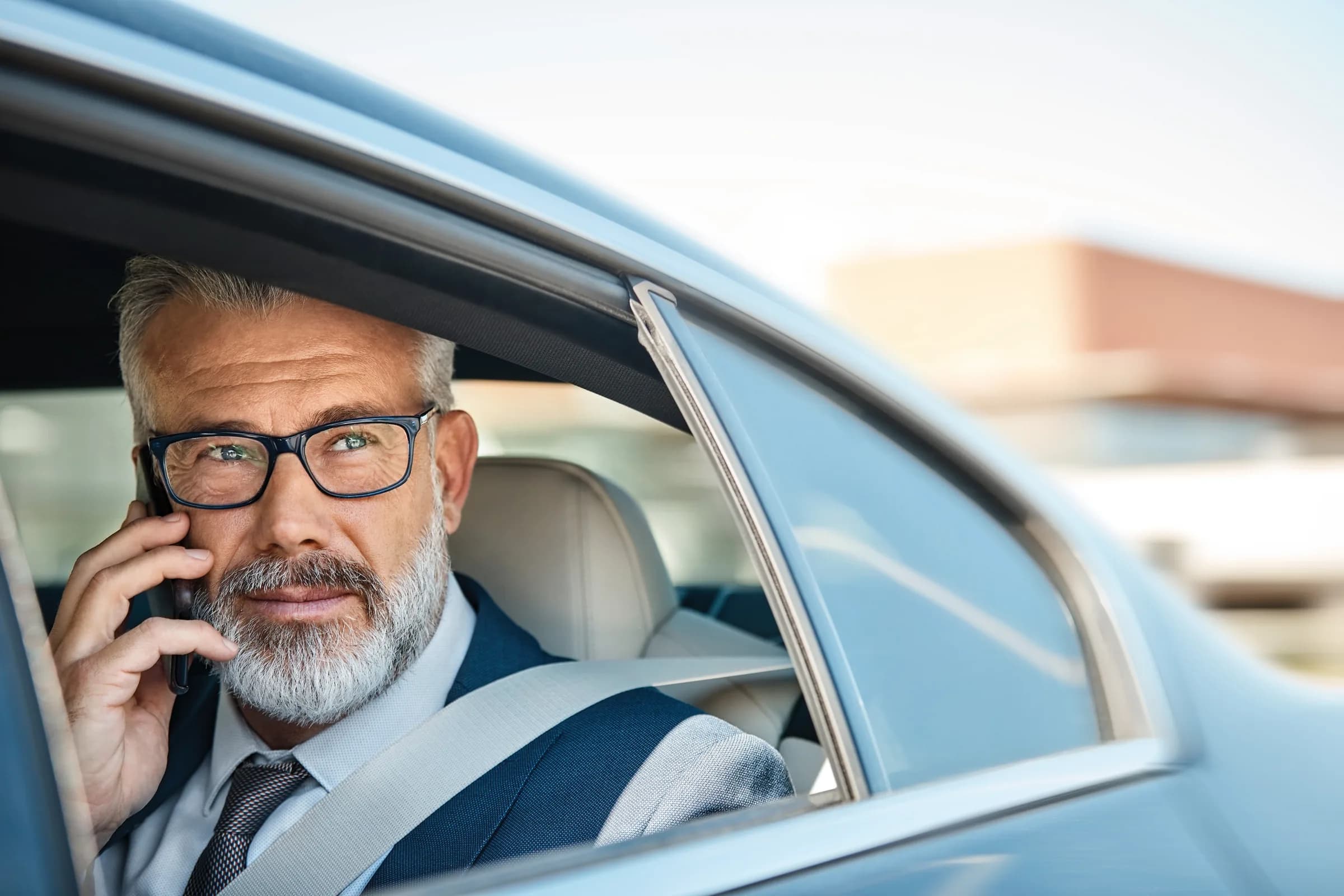 Cliente Quádriga en el asiento trasero de su vehículo, hablando con su concierge